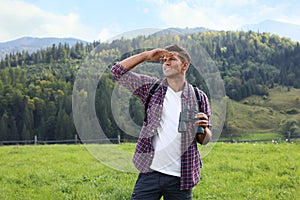 Man with backpack and binoculars in mountains