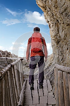 Man with a backpack during a hike on an old wooden bridge