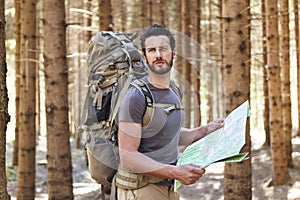 Man with Backpack and map searching directions