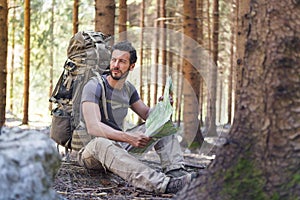 Man with Backpack and map searching directions