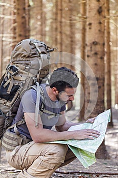 Man with Backpack and map searching directions
