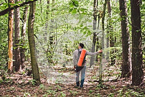 Man with Backpack and map searching directions in wilderness area. Tourist with backpack using map in forest. concept