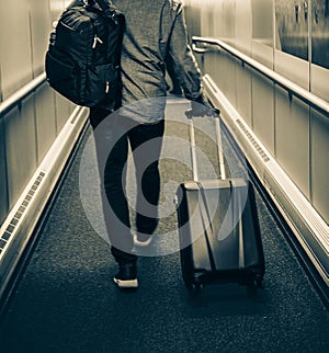 Man With Backpack, Suitcase Walking In Airport Terminal. Traveller On His Way To Flight Boarding Gate