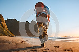 Man with backpack trail running on beach adventure travel vacations active healthy lifestyle outdoor