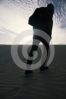Man with a backpack walking in the desert