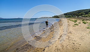 Man with backpack walking on a dirty beach