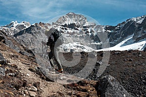 Man with Backpack walking up along sharp Ridge