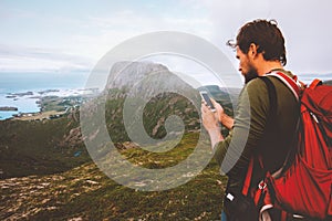 Man backpacker using smartphone navigation hiking in mountains travel blogger