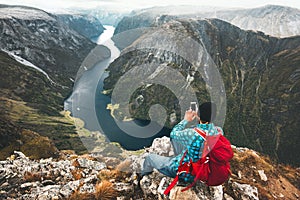 Man backpacker using smartphone relaxing on mountain top