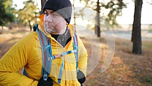 Man backpacker walking on pine forest. Successful man hiker with backpack at sunset time. Travel lifestyle wanderlust