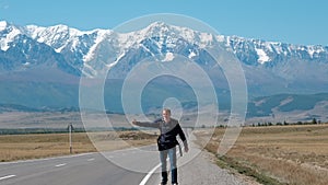 Man Backpacking Hitchhiking on a Mountain Road