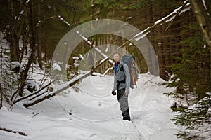 Man is backpacking in winter forest