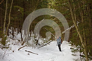 Man is backpacking in winter forest