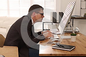 Man with bad posture working on computer in office