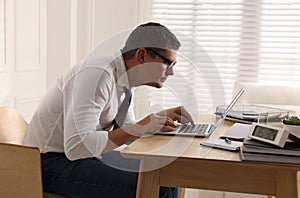 Man with bad posture working on laptop in office