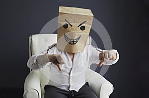 A man with a bag on his head, with a drawn angry emoticon, gloats emotionally.