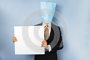 Man with bag over head holding blank sign
