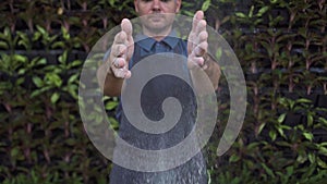 Man baker clapping hands with flour in bakery shop. Chef hands in flour while making pizza, pasta, baking bread and