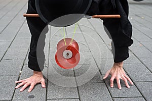 man balacing on hands playing with diabolo in the street