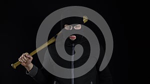 A man in a balaclava mask is standing with a baseball bat. A bandit stands on a black background with a baseball bat