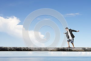 Man balancing on tree trunk high in the sky