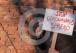 Man with banner Stop Spread. Man protests, calling governments to help fight corona virus. Person encourage scientists