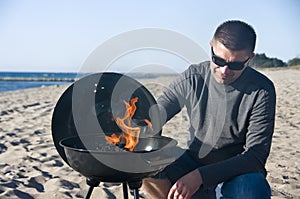 Man and barbecue on beach