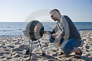 Man and barbecue on beach