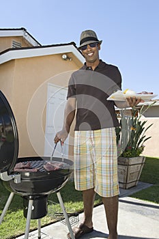 Man Barbequing In Lawn