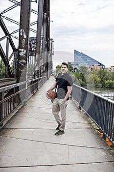Man With a Basketball Posing Near Railway Tracks