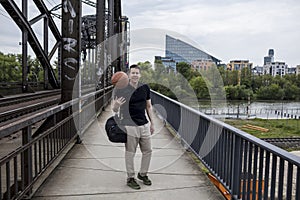 Man With a Basketball Posing Near Railway Tracks