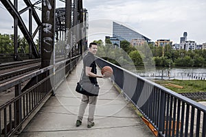 Man With a Basketball Posing Near Railway Tracks