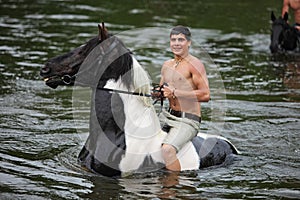 Man bathes horse in the river