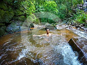 Man bathing in natural waterfall in forests at morning from different angle