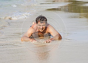 Man in bathingsuit is lying at the beach