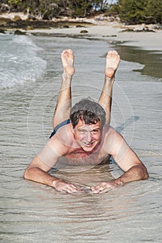 Man in bathingsuit is lying at the beach