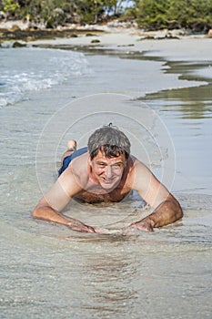 Man in bathingsuit is lying at the beach