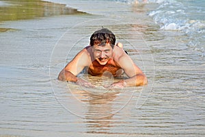 Man in bathingsuit is lying at the beach