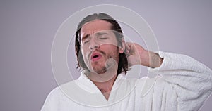 Man in bathrobe singing while combing his hair