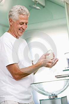 Man in bathroom applying aftershave photo