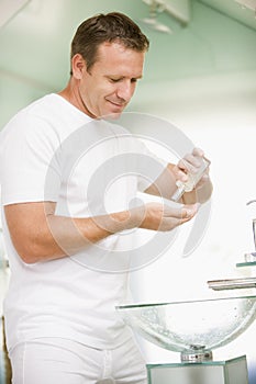Man in bathroom applying aftershave photo