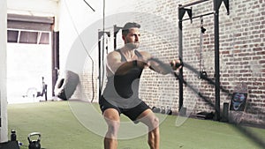 Man, battle ropes and exercise strength for arm workout in gym for cardio performance, muscle growth or challenge. Male