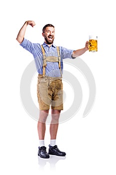 Man in bavarian clothes, holding beer, showing biceps