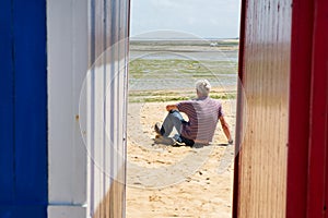 Man on the beach in front of beach huts