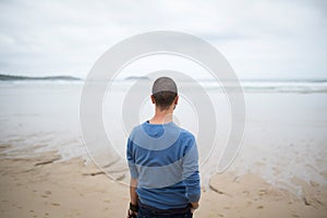 Man in the beach looking to the sea