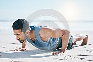 Man, beach and pushup on sand for workout, fitness or exercise for performance in summer sunshine. Young guy