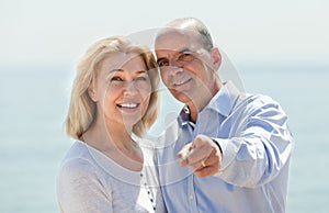 Man on the beach showing the hand something to his woman