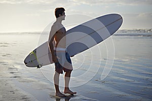 Man, beach and surfboard for waves, exercise or outdoor hobby in fitness, surfing or practice. Male person or surfer