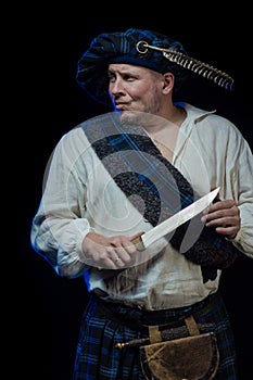 Man with a beard in a blue checkered Scottish costume