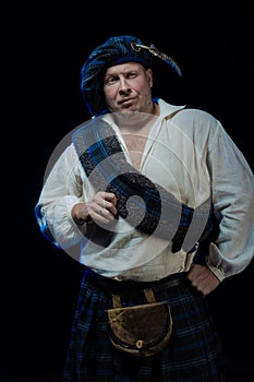 Man with a beard in a blue checkered Scottish costume